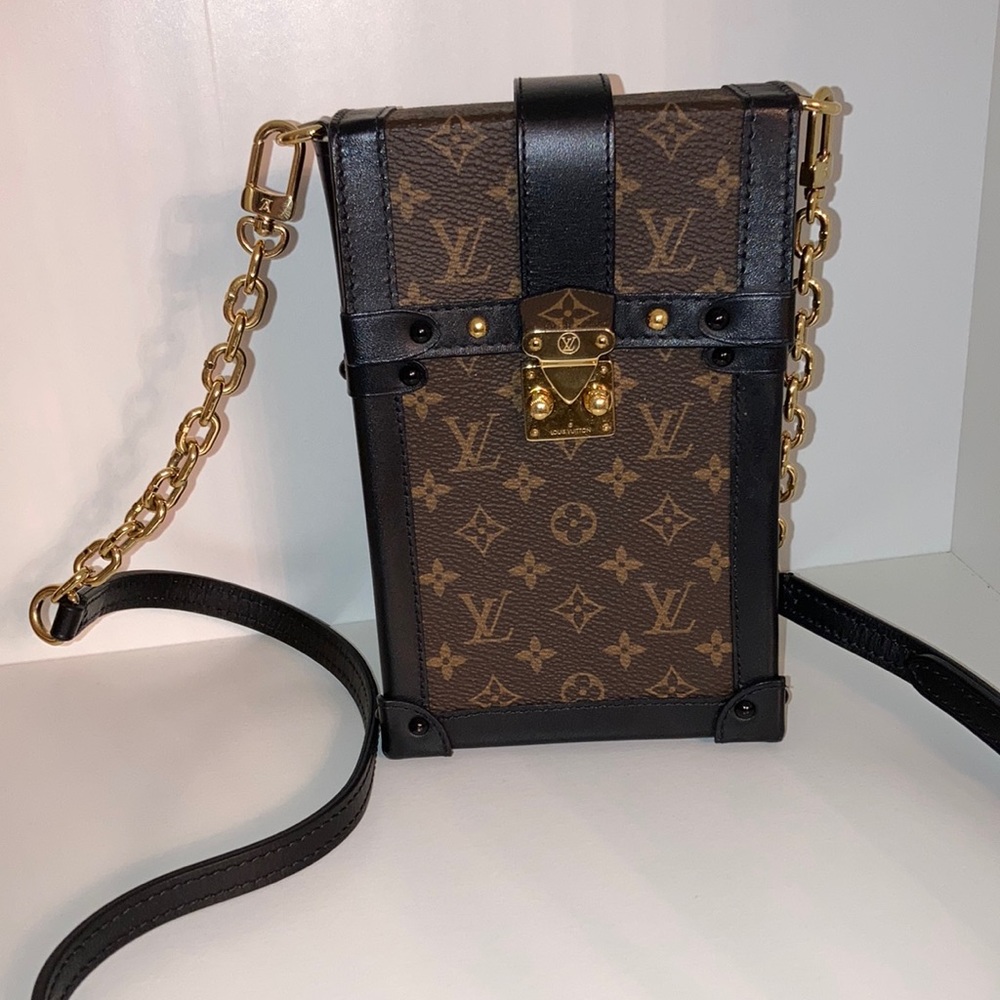 Louis Vuitton pochette trunk vertical in monogram with black trim.